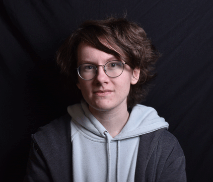 A young white person with short brown hair and glasses.